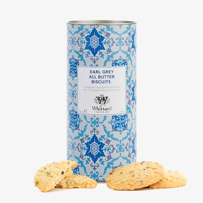 Decorative blue-patterned tin of Whittard Earl Grey All Butter Biscuits with golden tea-infused biscuits displayed in front.