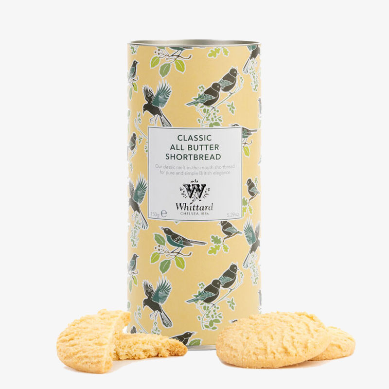 Decorative tin of Whittard Classic All Butter Shortbread with bird illustrations and golden shortbread biscuits displayed in front.