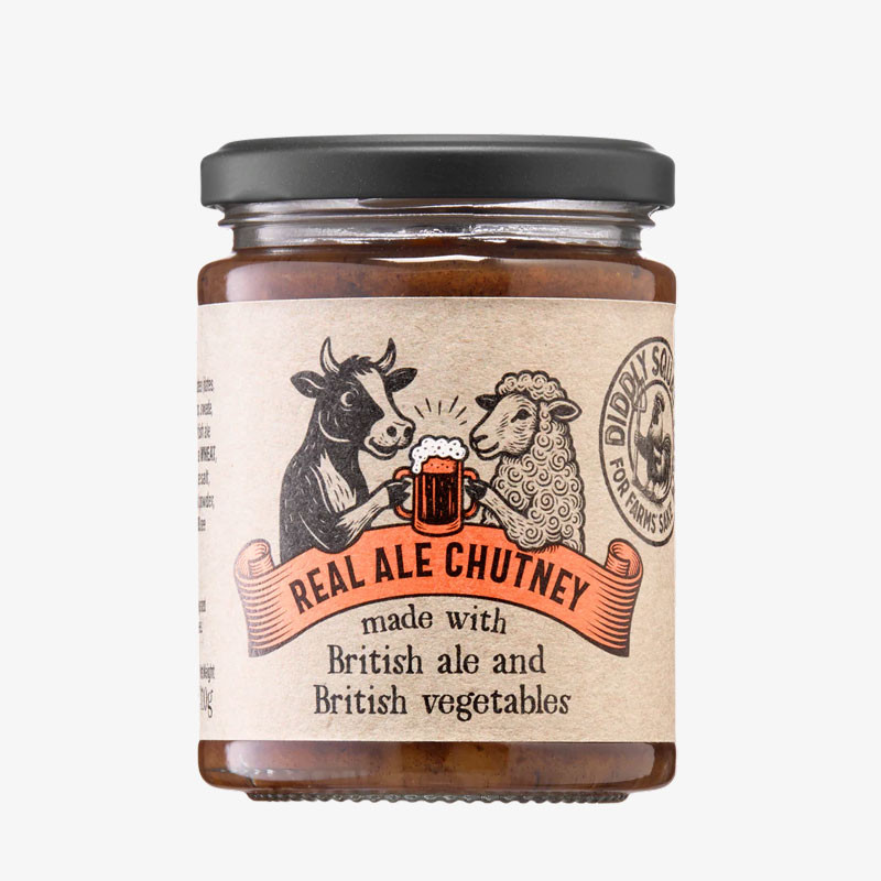 Jar of Real Ale Chutney with a black lid and a rustic label showing a cow and sheep sharing a mug of ale.