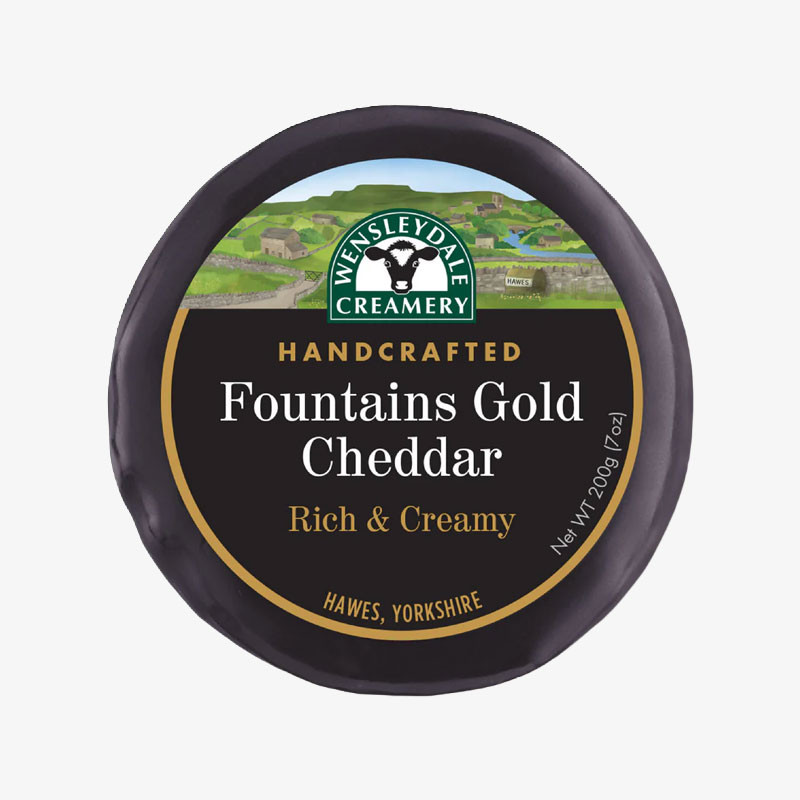 Round black wax-wrapped Wensleydale Creamery Fountains Gold Cheddar with a black and gold premium-style label.