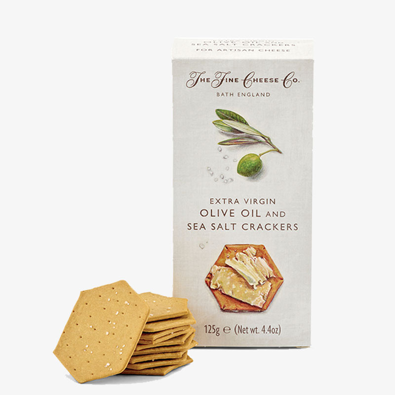 The Fine Cheese Co. Extra Virgin Olive Oil and Sea Salt Crackers box with a stack of hexagonal sea salt crackers displayed in front.