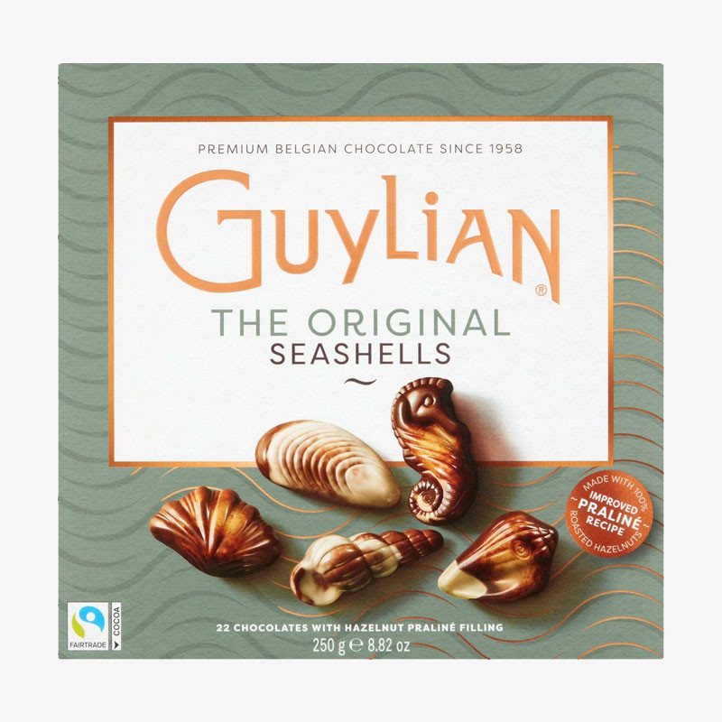 Box of Guylian The Original Seashells Belgian chocolates featuring assorted seashell-shaped pralines on a sage green and white box.