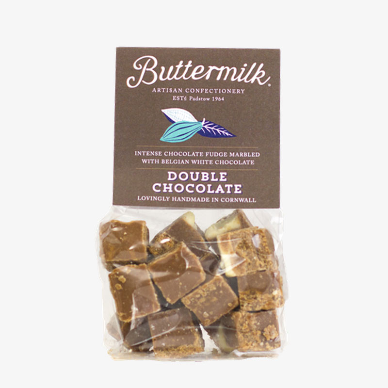 Bag of Buttermilk Double Chocolate Fudge with a dark brown label and visible cubes of chocolate fudge marbled with white chocolate.