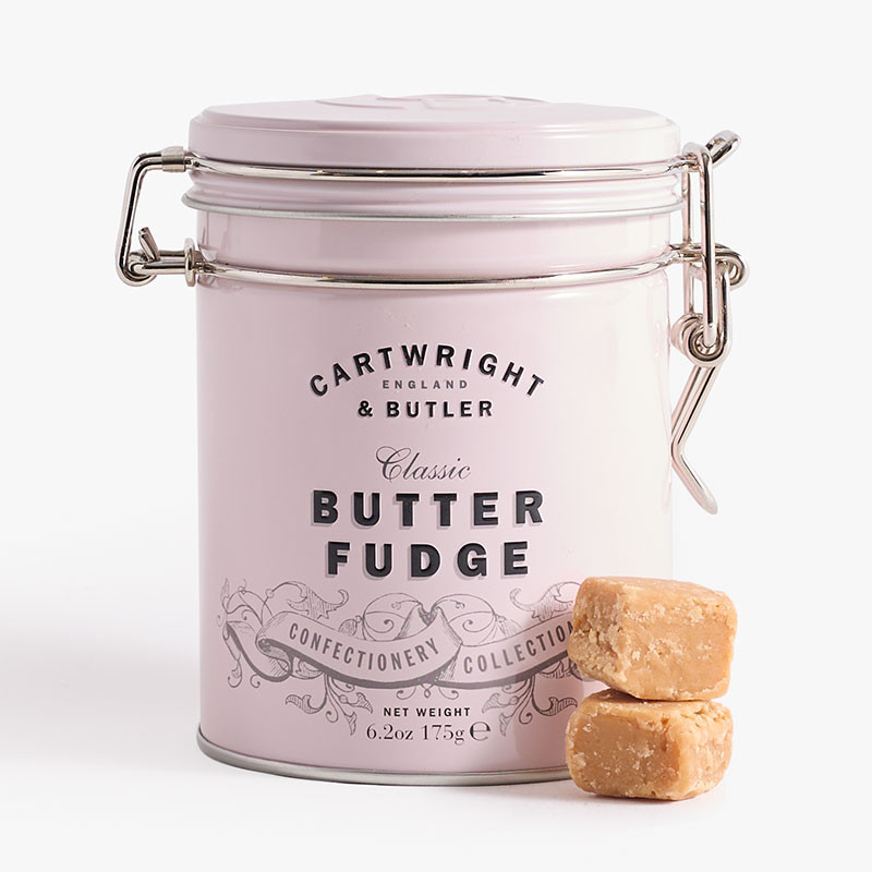 Pale pink clip-top tin of Cartwright & Butler Classic Butter Fudge with two stacked cubes of butter fudge displayed in front.