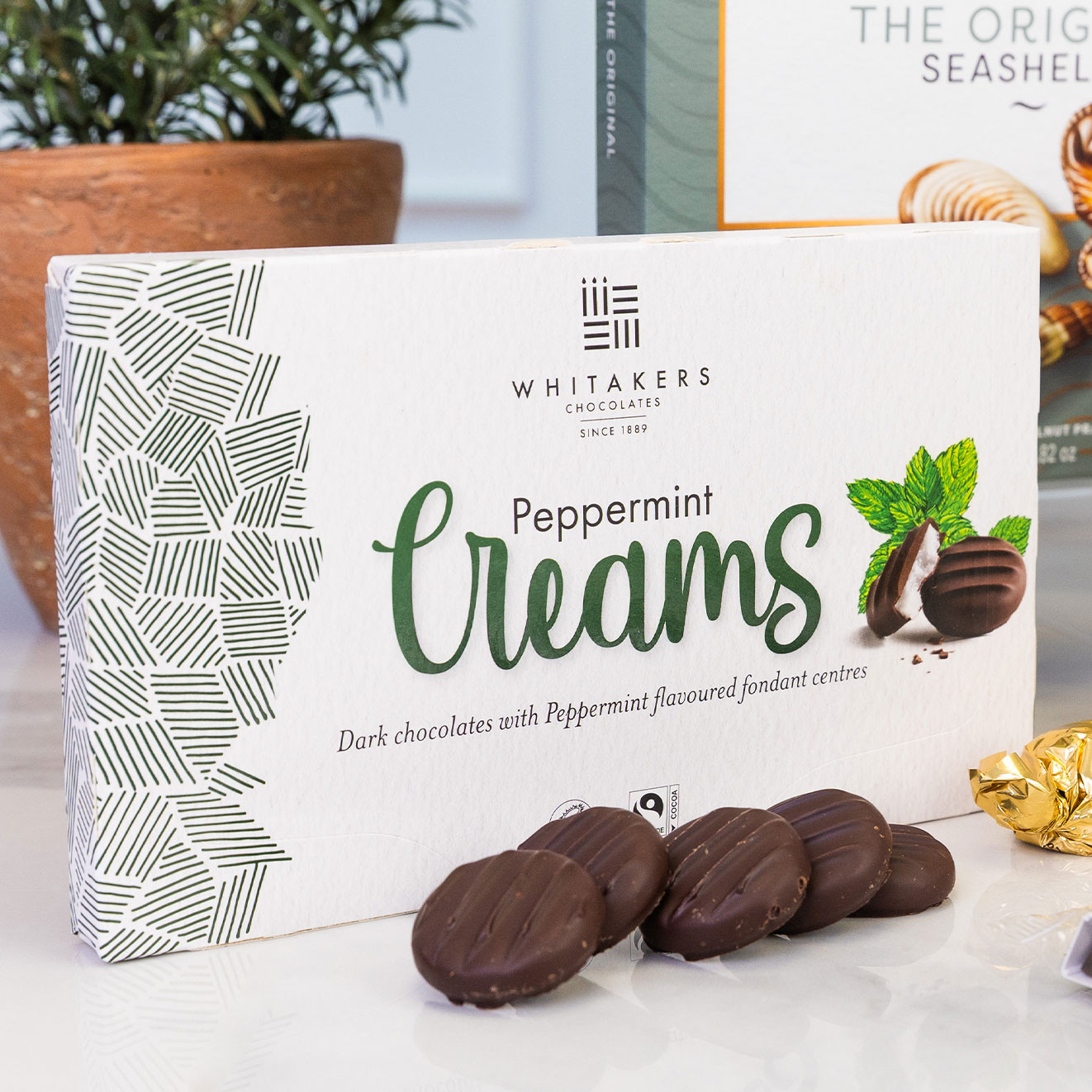 Box of Whitakers Peppermint Creams dark chocolates with peppermint fondant centres displayed with individual chocolates.