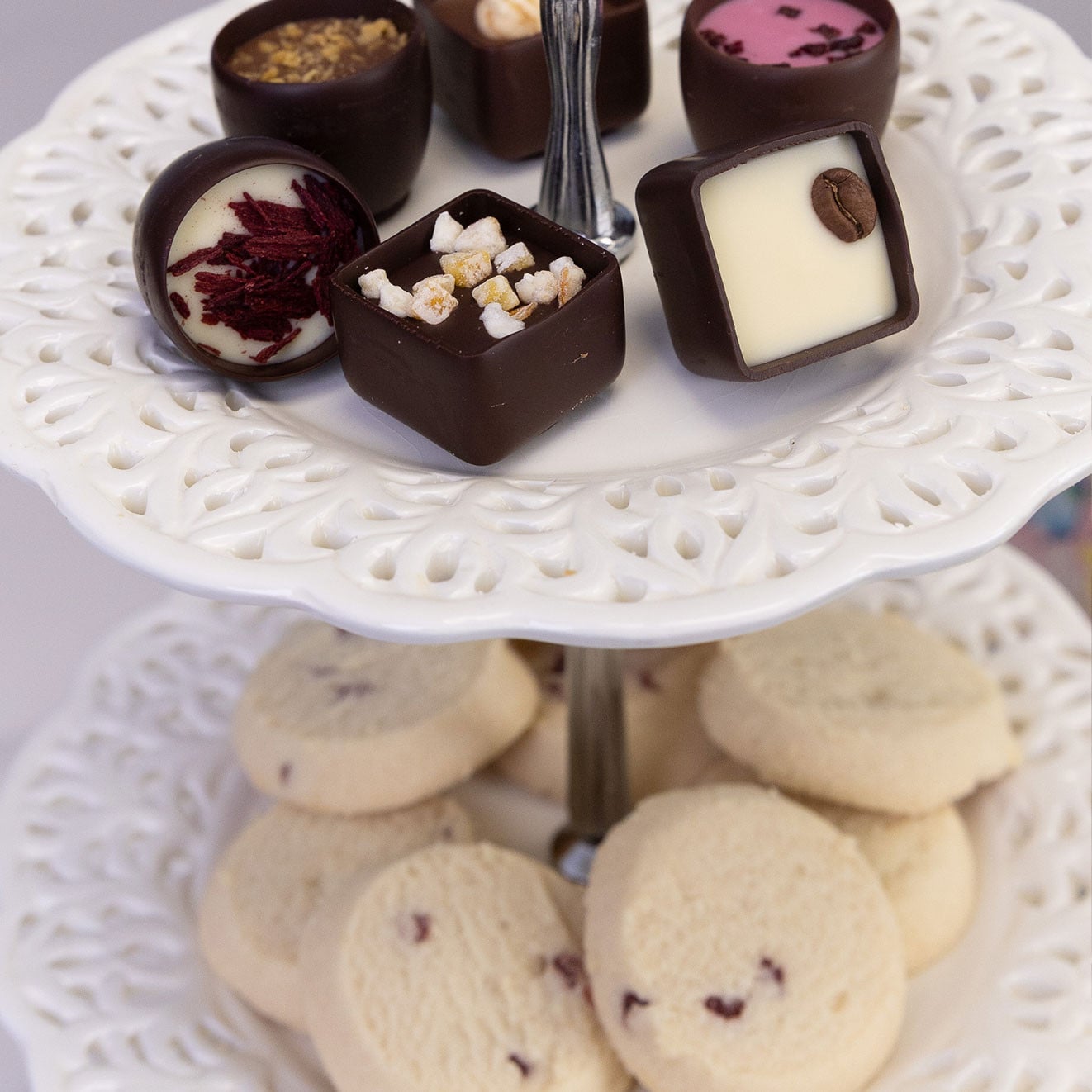 Selection of Butlers assorted chocolates displayed on a tiered cake stand above biscuits.