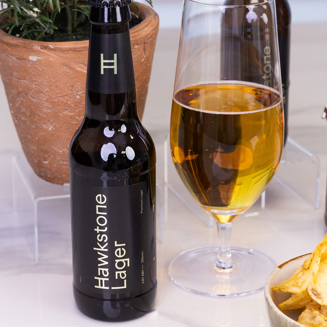 Bottle of Hawkstone Premium Lager served alongside a glass of golden lager.