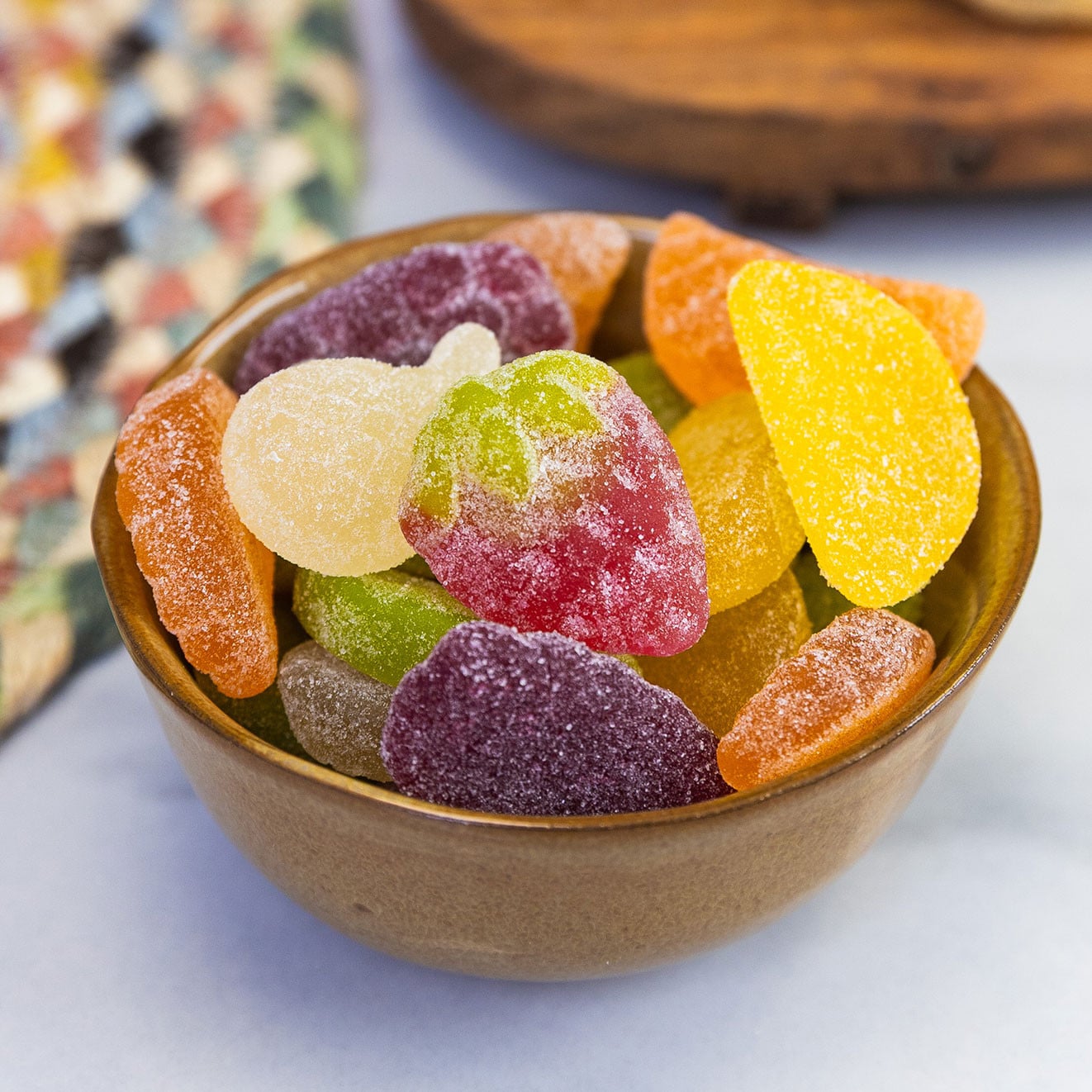 Colourful sugar-coated fruit jellies served in a ceramic bowl.