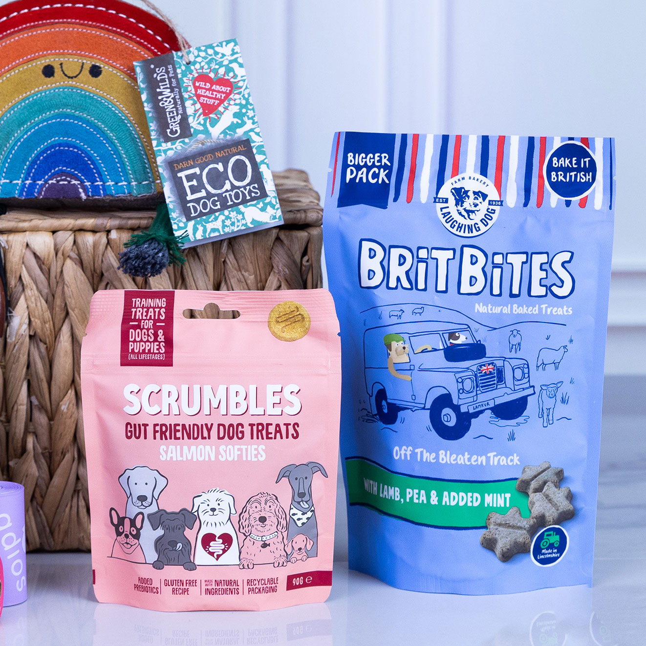 Scrumbles Salmon Softies dog treats alongside Laughing Dog Brit Bites natural baked treats displayed on a countertop.