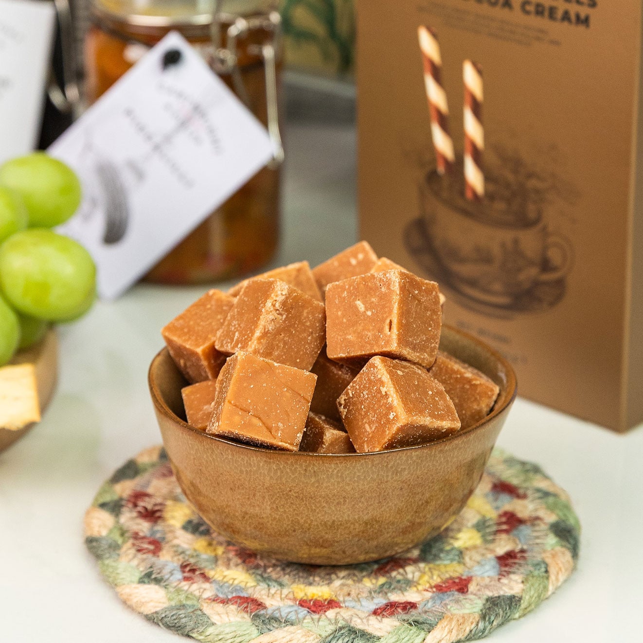 Bowl of fudge pieces displayed in front of Cartwright & Butler Crispy Wafer Rolls packaging.