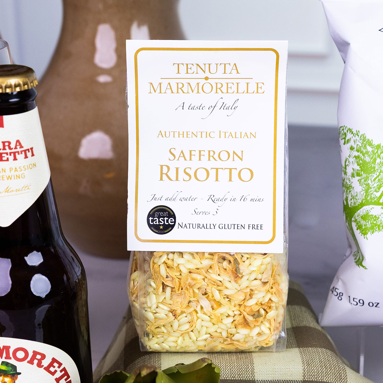 Pack of Tenuta Marmorelle Authentic Italian Saffron Risotto displayed alongside Birra Moretti lager and premium Italian pantry ingredients.
