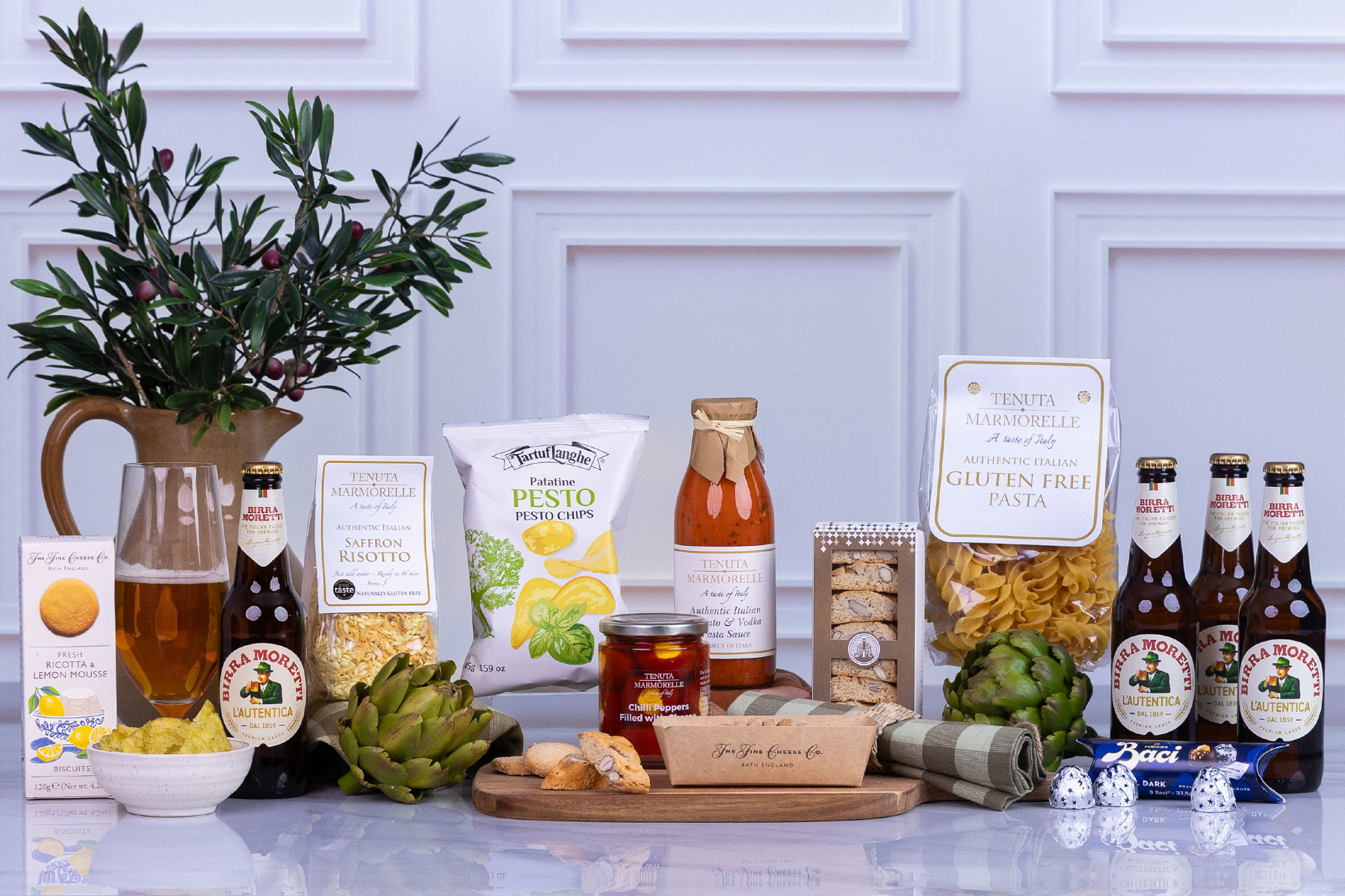 Italian-themed gourmet hamper featuring Birra Moretti lager, artisan pasta, saffron risotto, tomato and vodka pasta sauce, pesto chips, chilli peppers stuffed with cheese, biscotti, dark chocolates and premium Italian pantry treats.