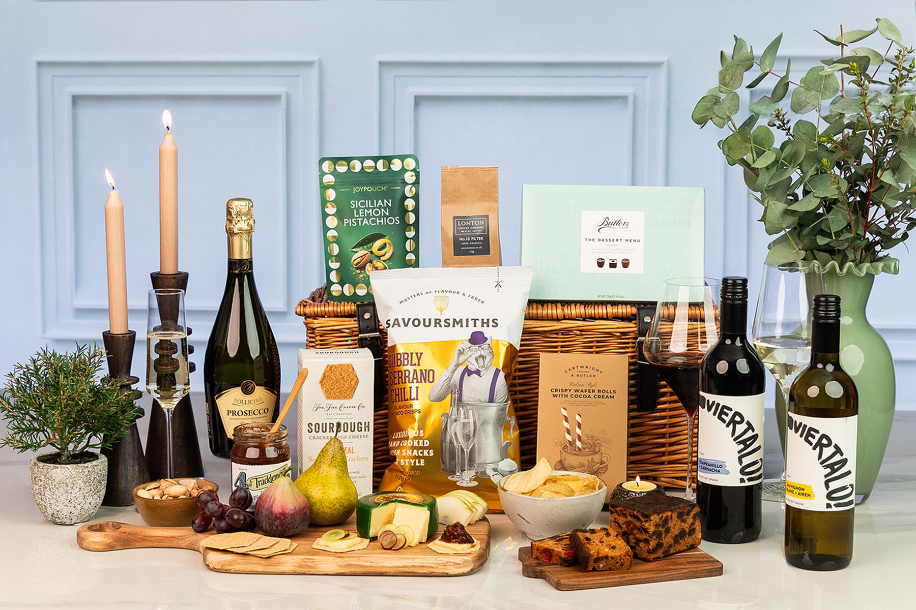 Luxury wicker hamper featuring Prosecco, red and white wine, artisan cheese, sourdough crackers, gourmet crisps, coffee, pistachios, fruit cake, chocolates and premium sweet and savoury treats.
