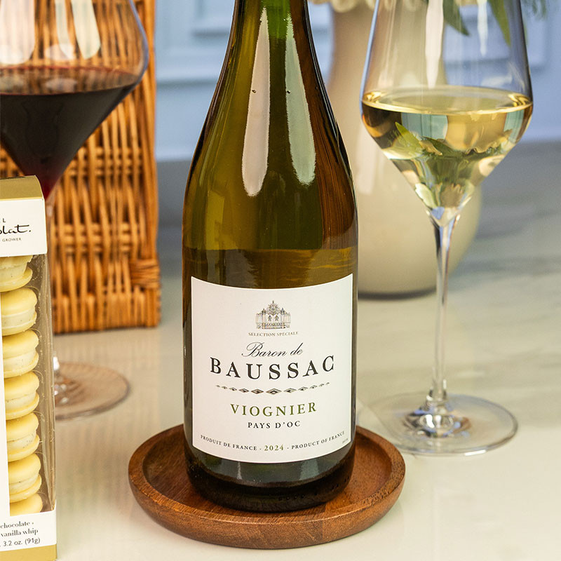 Bottle of Baron de Baussac Viognier French white wine displayed with a filled white wine glass and luxury hamper.