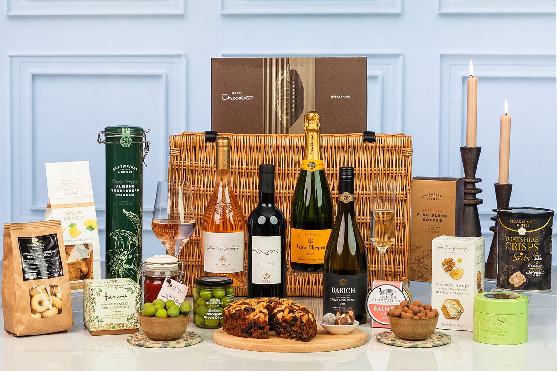 Luxury wicker hamper featuring Veuve Clicquot Champagne, Whispering Angel rosé, red and white wines, artisan sweet and savoury treats, fruit cake, chocolates and gourmet snacks.