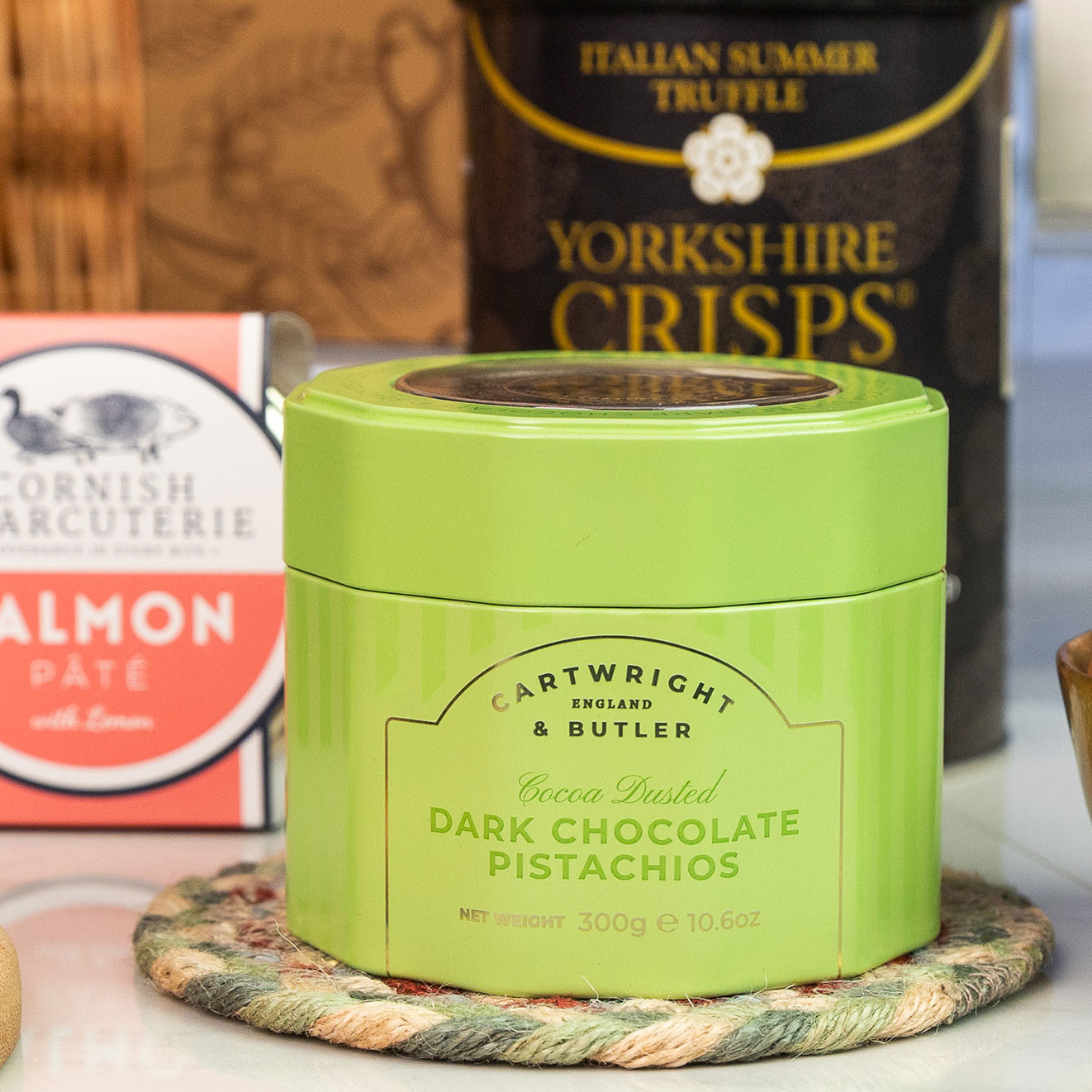 Cartwright & Butler Cocoa Dusted Dark Chocolate Pistachios presented in a reusable green gift tin.