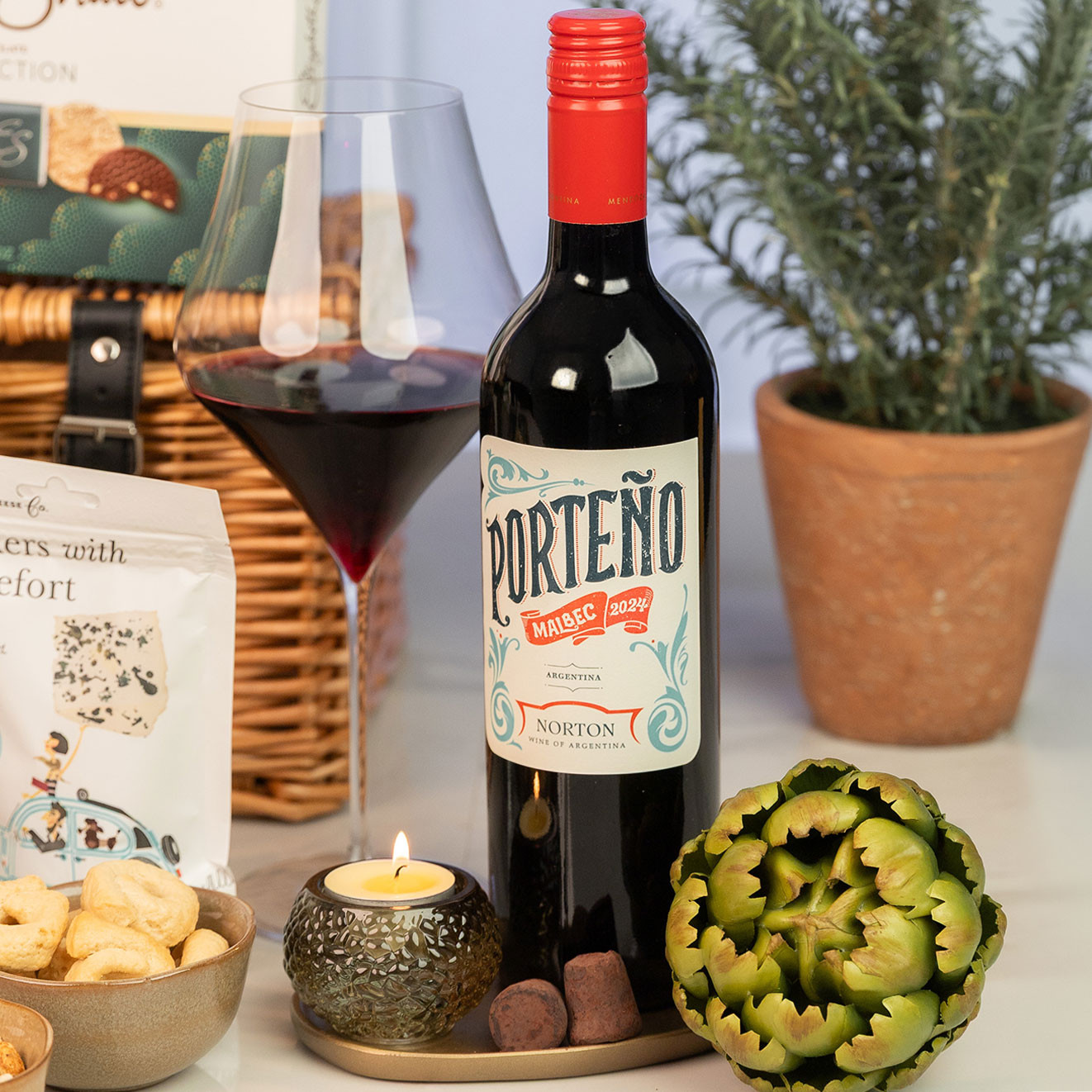 Bottle of Porteño Malbec from Argentina served with a glass of red wine, ideal for pairing with gourmet savoury snacks.