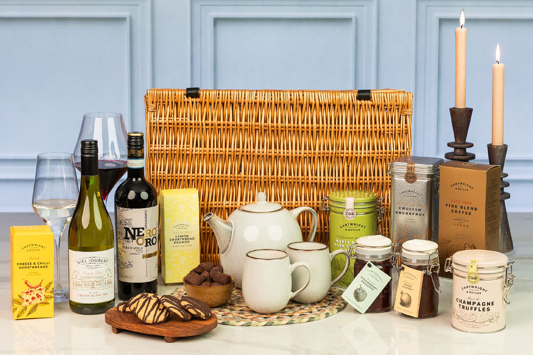 Luxury wicker hamper filled with premium wines, artisan tea and coffee, gourmet biscuits, preserves, chutney and indulgent chocolate treats for elegant gifting.