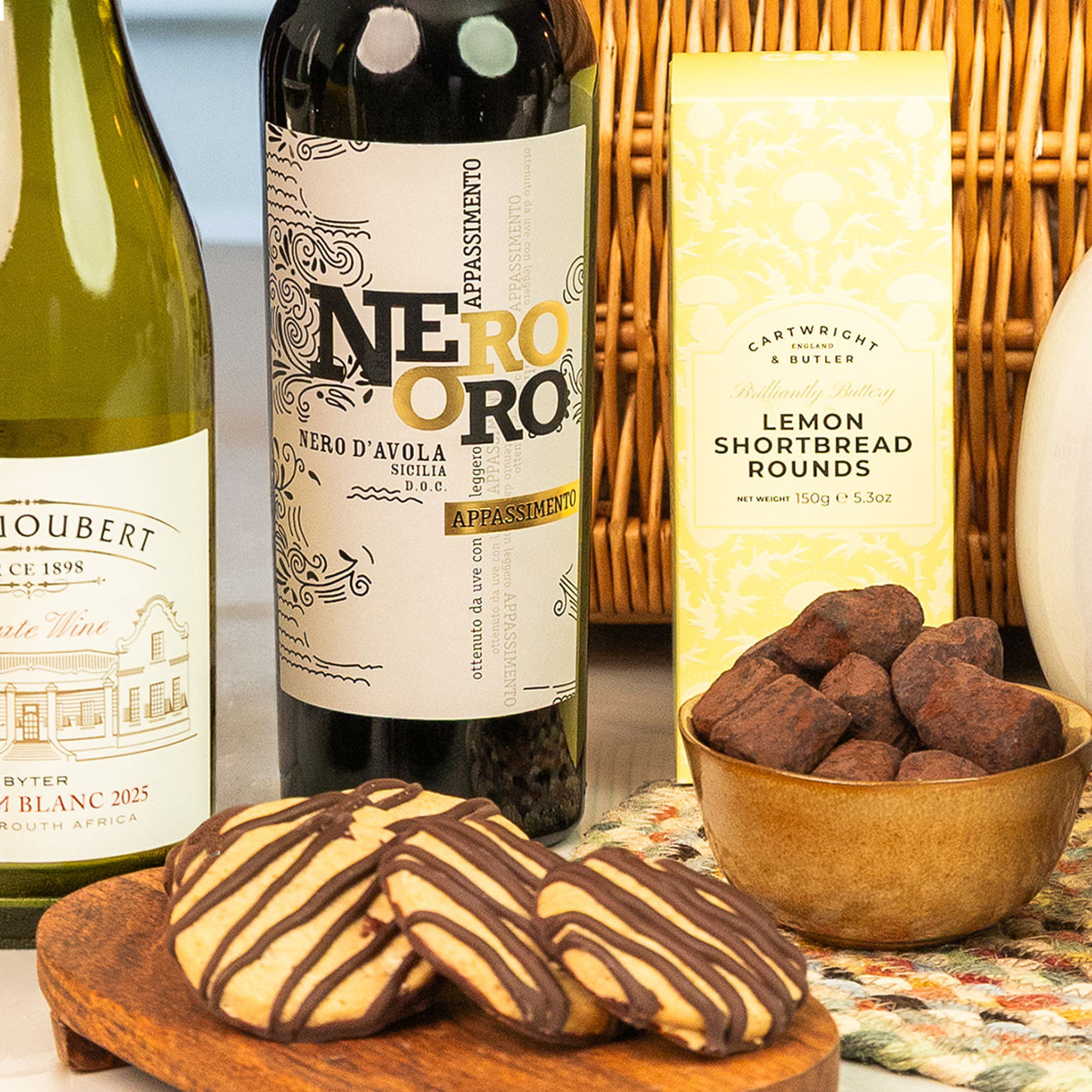 Nero Oro Sicilian red wine with Cartwright & Butler Lemon Shortbread Rounds, chocolate-drizzled biscuits and cocoa-dusted truffles for an indulgent treat.