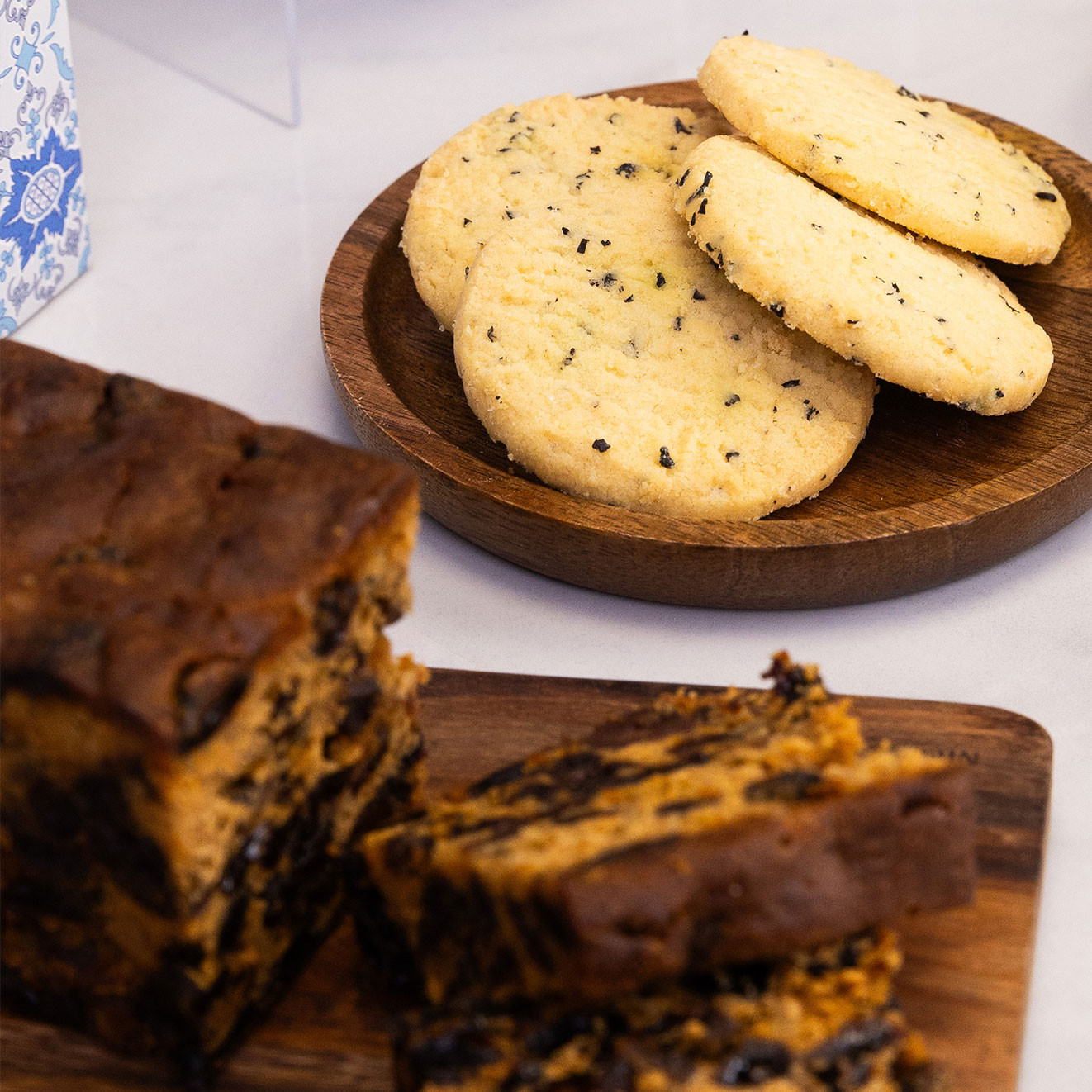 Rich fruit cake slices served alongside buttery savoury biscuits, perfect for enjoying with a traditional cup of tea.