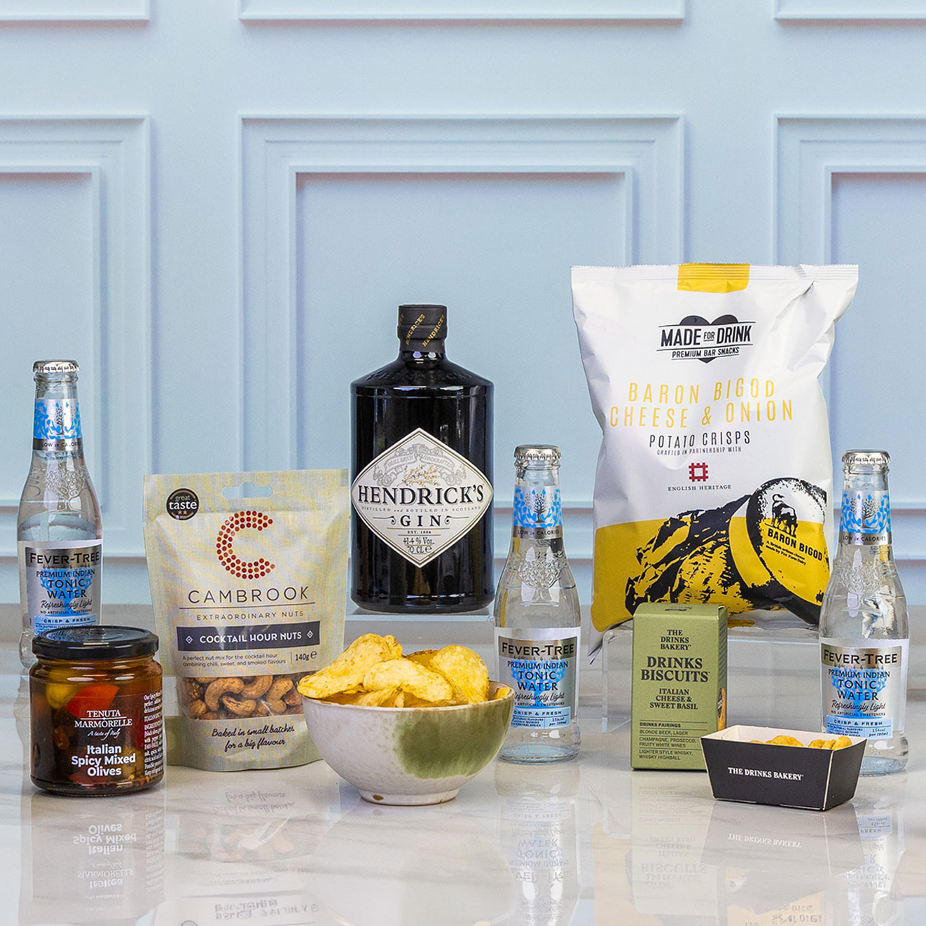 Close up of the Premium Hendrick's Gin gift set featuring Hendrick's Gin, Fever-Tree light tonic water, cocktail snacks, mixed olives, savoury biscuits and crisps for the perfect gin and tonic experience.