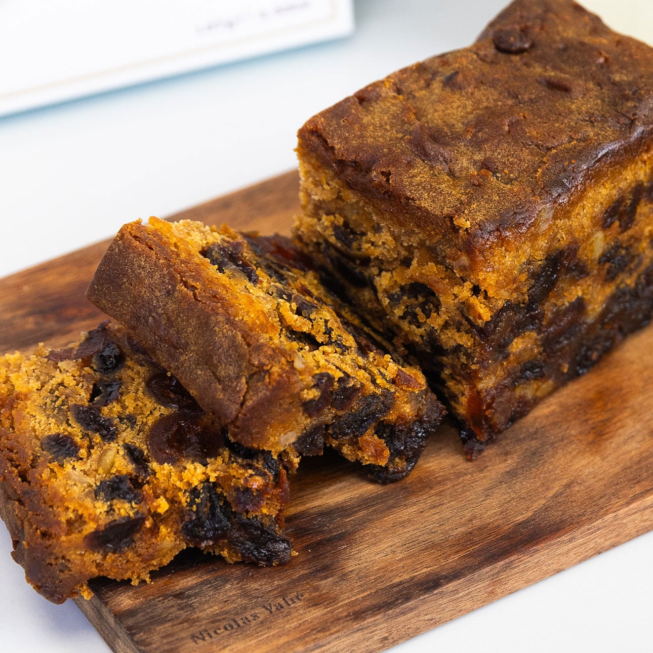 Traditional rich fruit cake sliced on a wooden serving board, packed with dried fruit and ideal for afternoon tea.