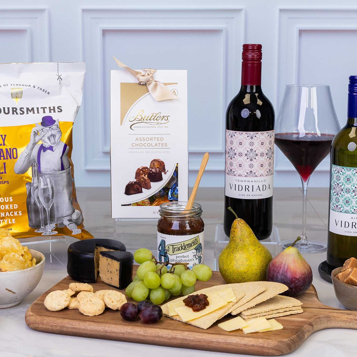 Close-up of the Luxury wine and gourmet food hamper featuring Spanish red and white wines, artisan chocolates, savoury snacks, cheese, crackers, chutney, fudge and fruit.