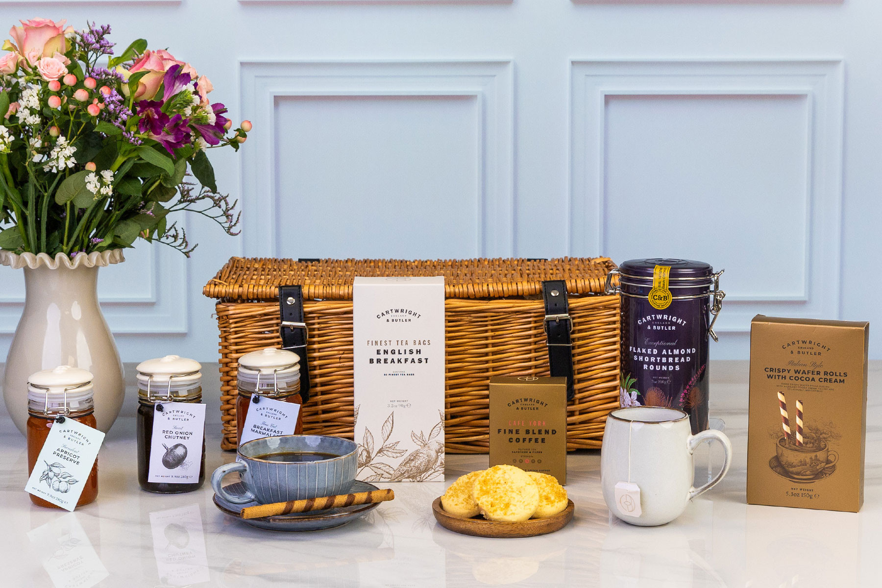 Luxury Cartwright & Butler hamper in a willow basket with premium tea, coffee, preserves, biscuits, cocoa wafer rolls and gourmet pantry treats.