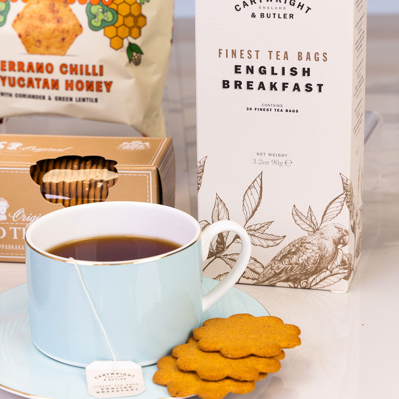 Cartwright & Butler English Breakfast tea served in a blue teacup with crisp biscuits, perfect for a relaxing afternoon tea break.