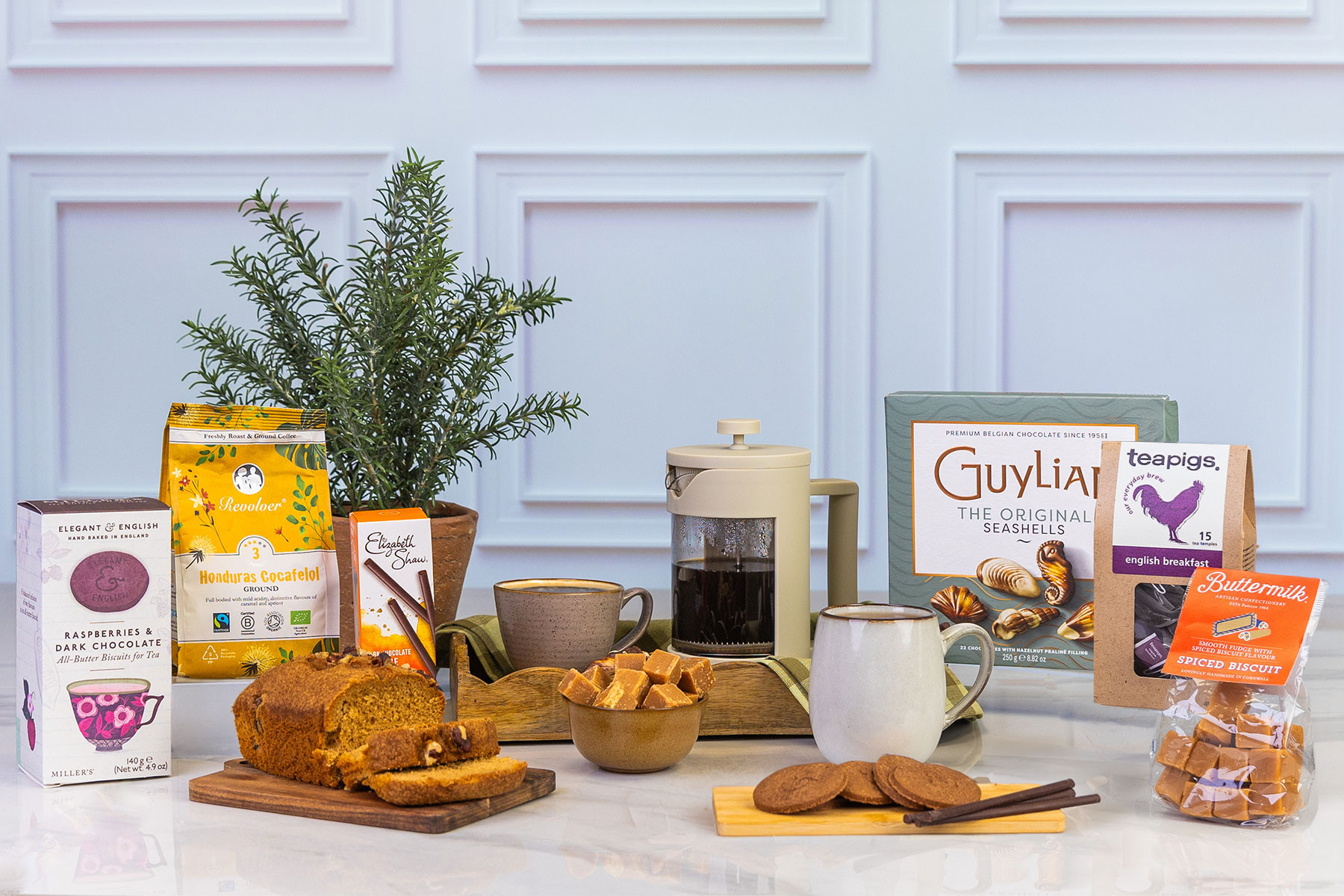 Coffee and chocolate gift hamper featuring premium ground coffee, Belgian chocolates, artisan fudge, breakfast tea, biscuits and sweet treats, styled around a cafetière for cosy moments.