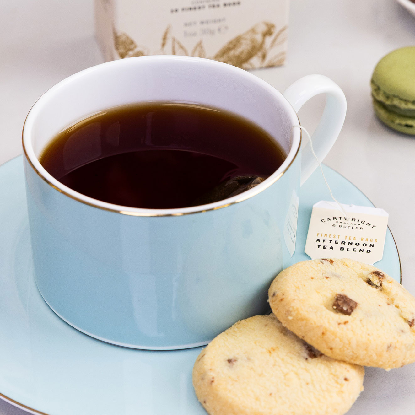 Cup of Cartwright & Butler Afternoon Blend tea served with chocolate chip biscuits, creating a comforting afternoon tea moment.
