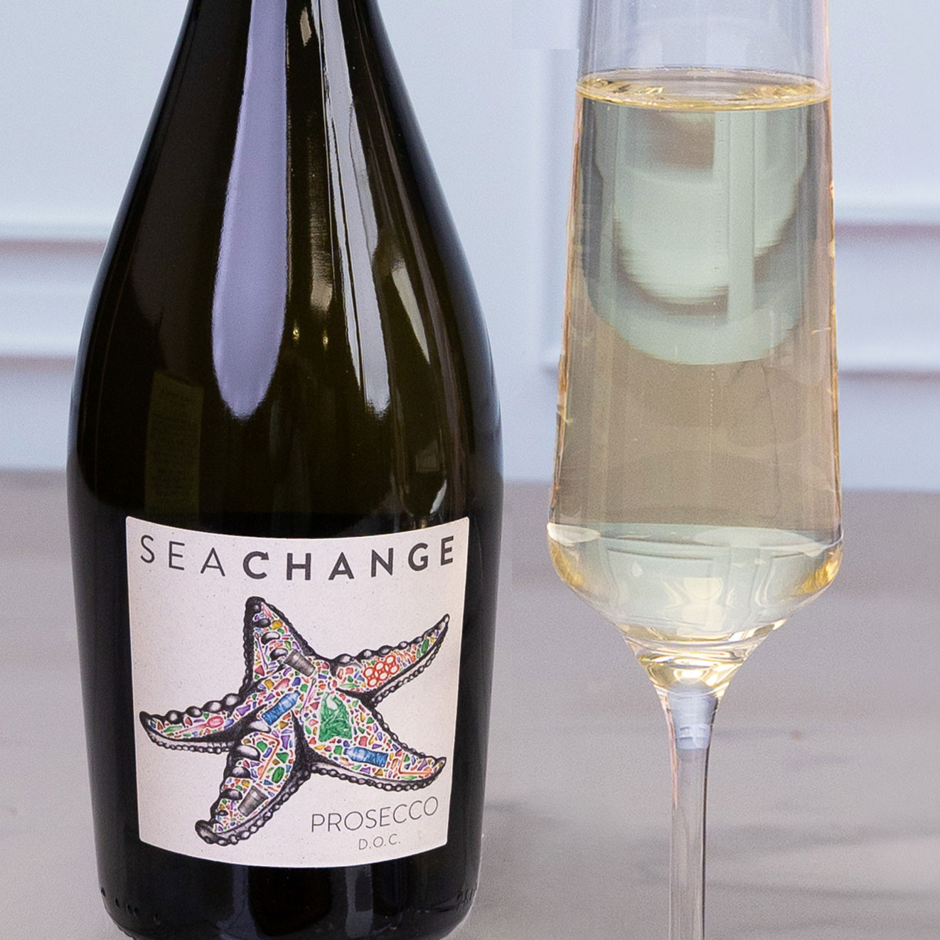 Bottle of Sea Change Prosecco D.O.C. beside a filled champagne flute, offering crisp Italian sparkling wine with a fresh, celebratory character.