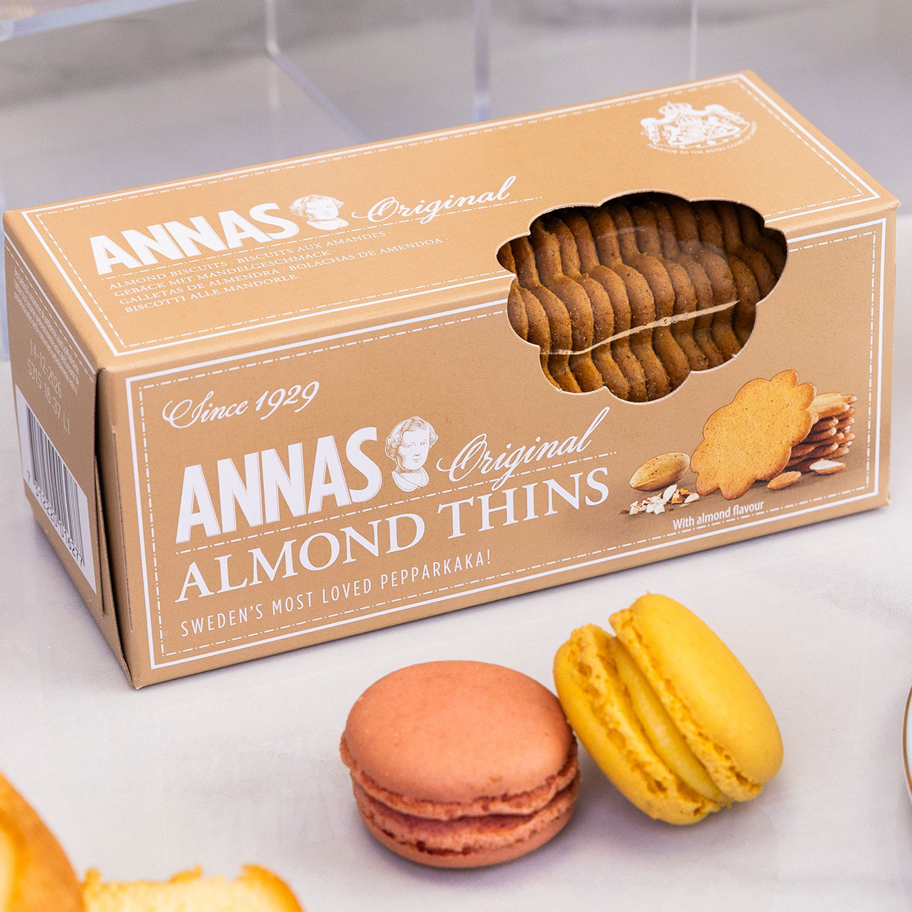 Annas Original Almond Thins, crisp Swedish almond biscuits presented with colourful macarons, perfect for enjoying with tea or coffee.