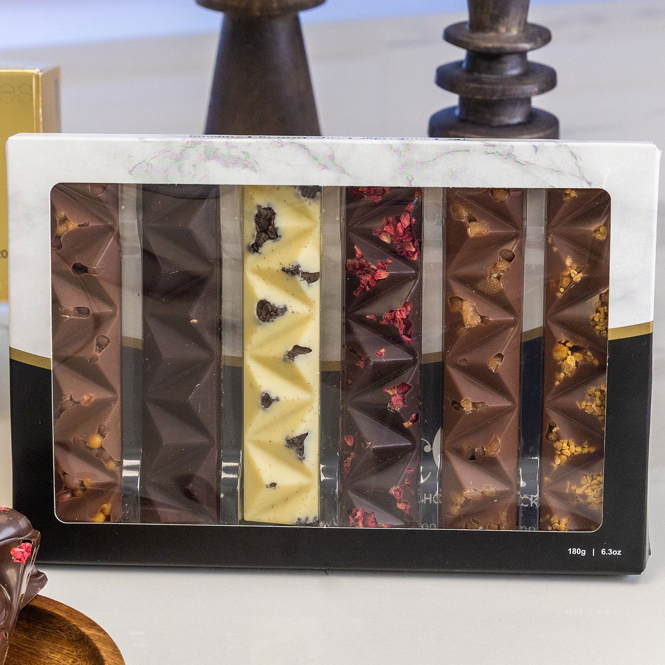 Selection box of artisan chocolate bars featuring milk, dark and white chocolate with fruit and caramel inclusions, presented in a premium gift box.