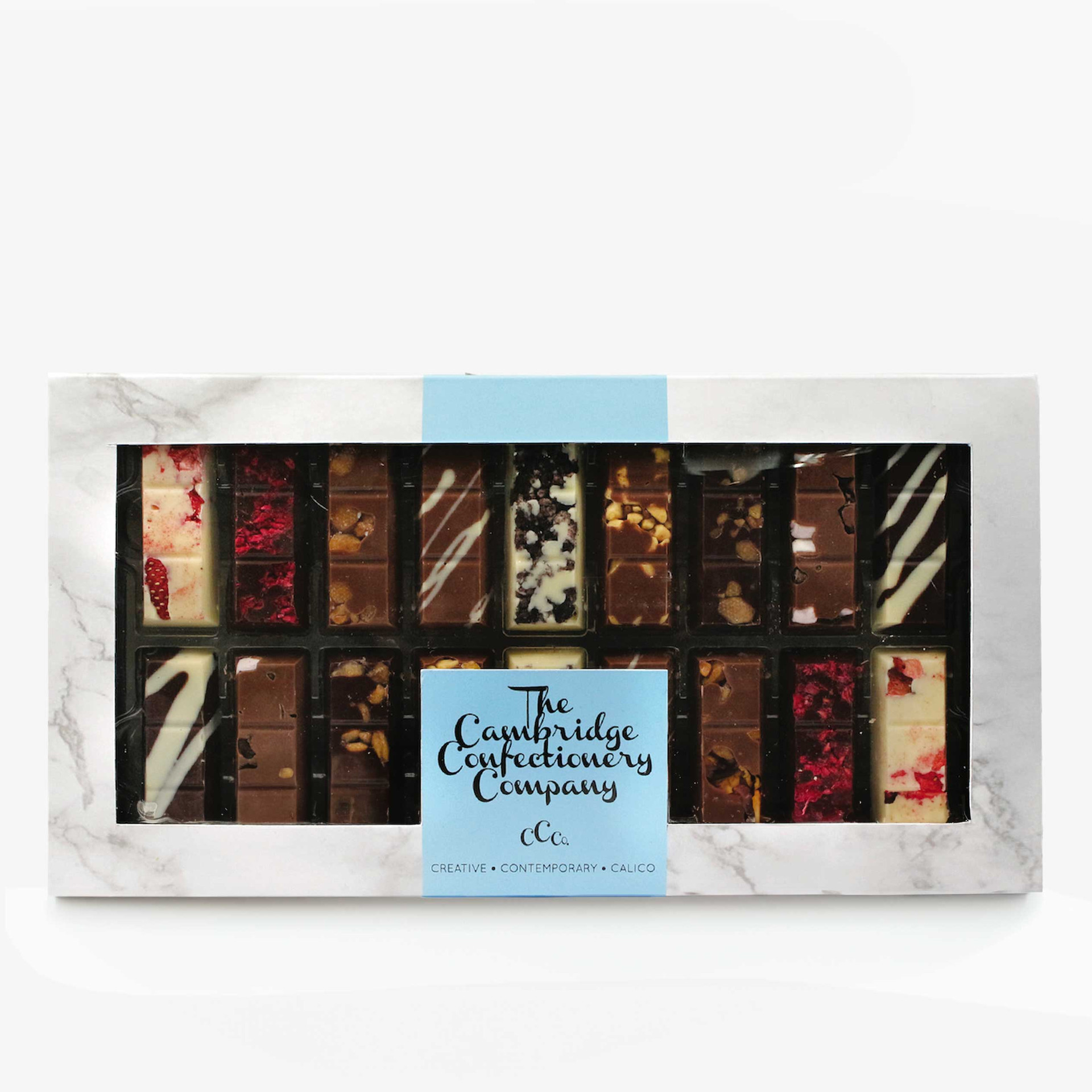 The Cambridge Confectionery Company chocolate selection box, featuring assorted milk, dark and white chocolate bars with nuts, fruit pieces and decorative toppings, presented in a marble-effect gift box with a clear window.