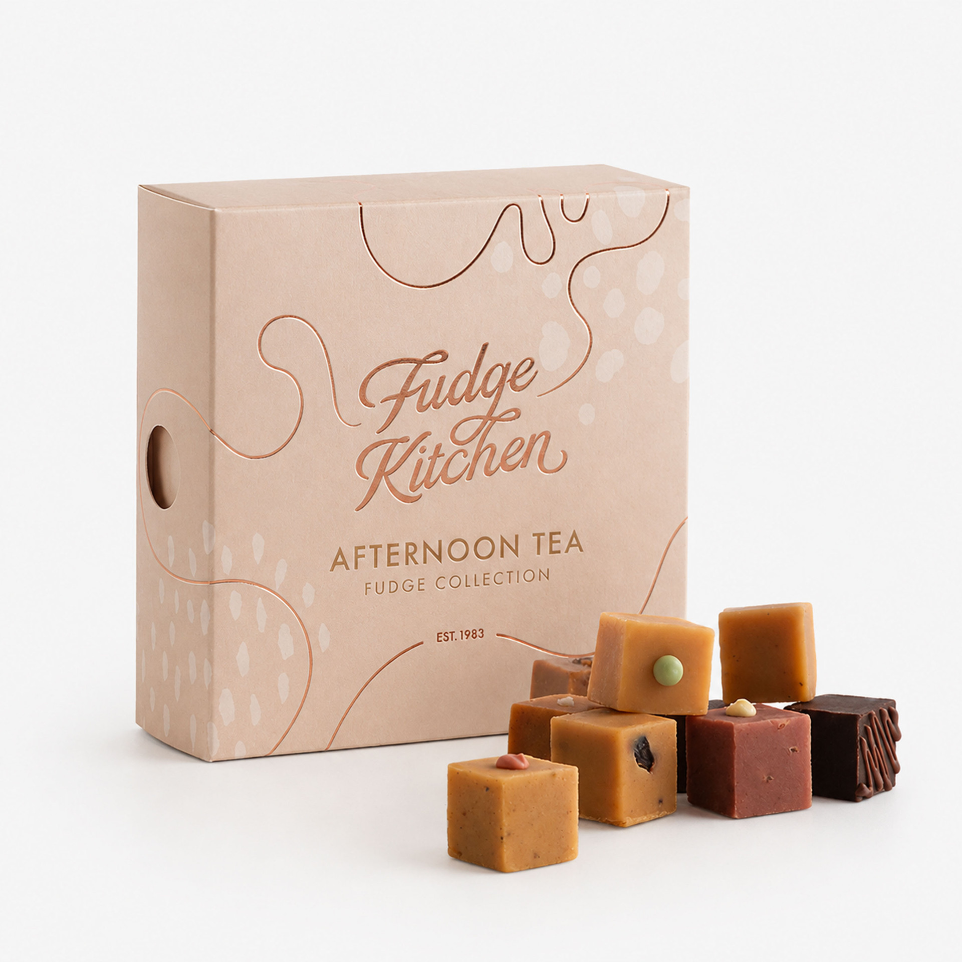 Fudge Kitchen Afternoon Tea Fudge Collection gift box with an assortment of dessert-inspired fudge pieces displayed in front.