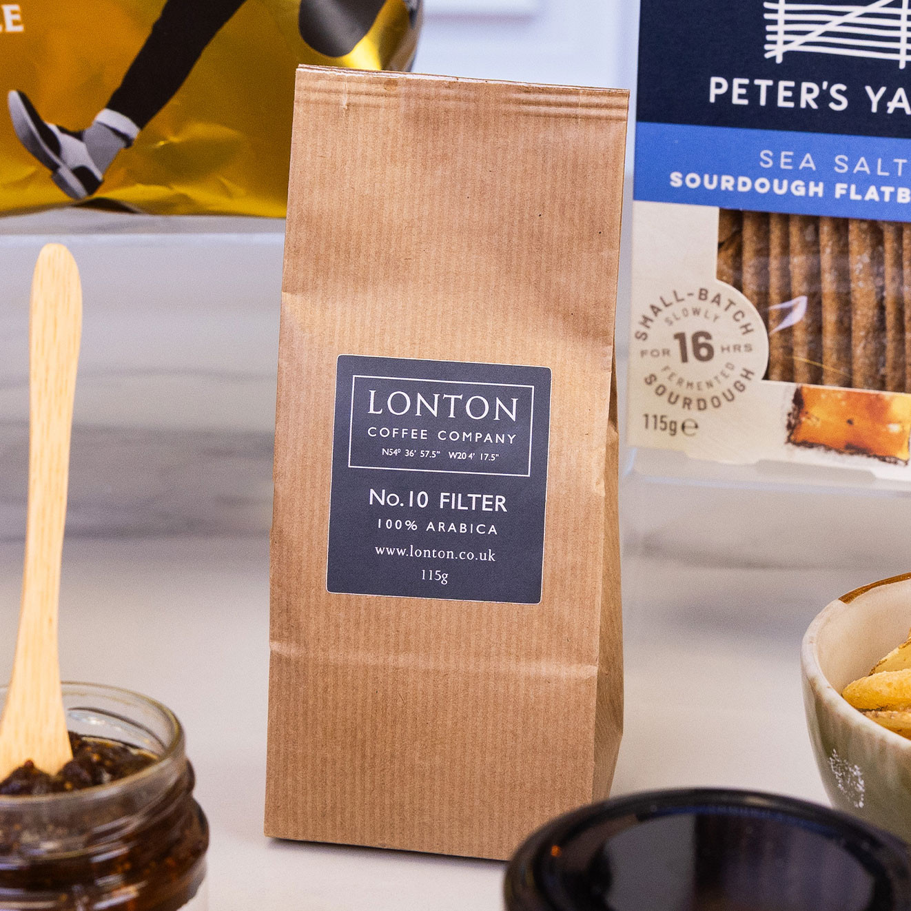 Bag of Lonton Coffee Company No.10 Filter 100% Arabica coffee, displayed alongside savoury snacks and crackers.