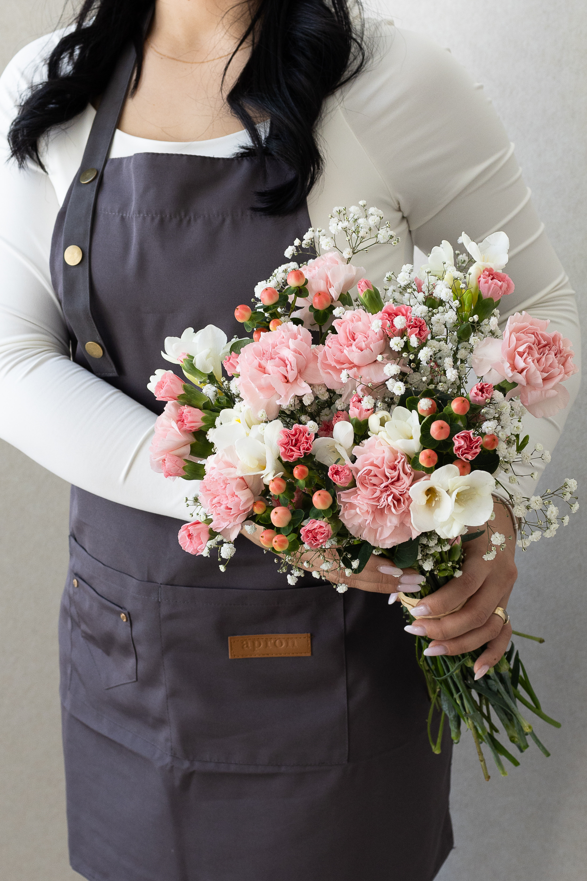 Pink carnation and white freesia bouquet with hypericum berries.