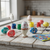 Painted easter eggs on a white wooden table, in front of a sunny window.