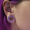 SoScene Hollow Lavender Opalite Glass Ear Plug Gauges, close-up of a person's ear showcasing the lavender opalite glass ear plug gauge.