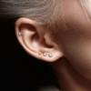 CZ Prong Set Threadless Top PVD Over Surgical Steel Push in Style Labret Flat Back Studs, close-up of woman's ear with multiple small diamond-studded earrings.