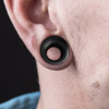 SoScene Hollow Concave Black Areng Organic Double Saddle Ear Plugs, black ear plugs worn in an ear.
