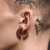 SoScene Round hangers Organic Saba Wood Round Ear Spiral Taper, image of a person's ear with a wooden spiral taper earring.