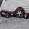 SoScene Star Crushed Turquoise Filled Organic Sono Wood Double Flared Saddle Plugs, set of five wooden ear plugs with star design, orange coil accents, and turquoise crushed stone inlays.
