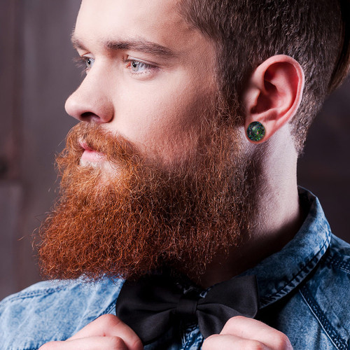 SoScene Dark Multi Color Sparkle Galaxy Double Flared Glass Plugs, close-up of a man with a beard and ear gauges wearing the jewelry.
