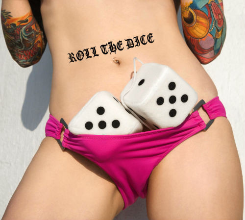 SoScene Random Bag Of Plugs 5 Pairs Total, image of a woman with colorful tattoos on her arms and a tattoo that reads 'ROLL THE DICE' on her stomach, holding a white pair of plug devices with black dots around her hips.