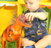 child playing with jumbo soft feel red T-Rex toy