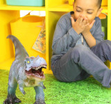 Boy playing with our blue T-rex toy dinosaur
