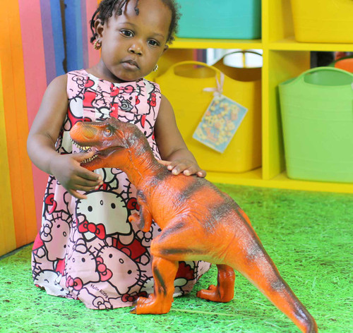 Child playing with our red T-rex dinosaur toy figure