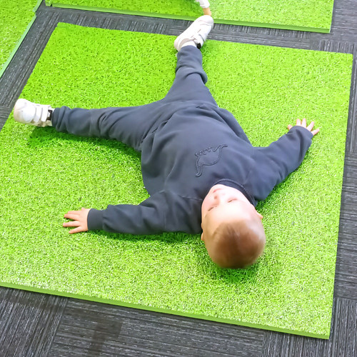 Boy laying down on our foam play mat